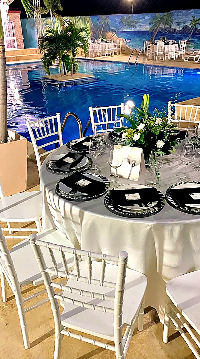 Mesa redonda con sillas tiffany junto a la piscina